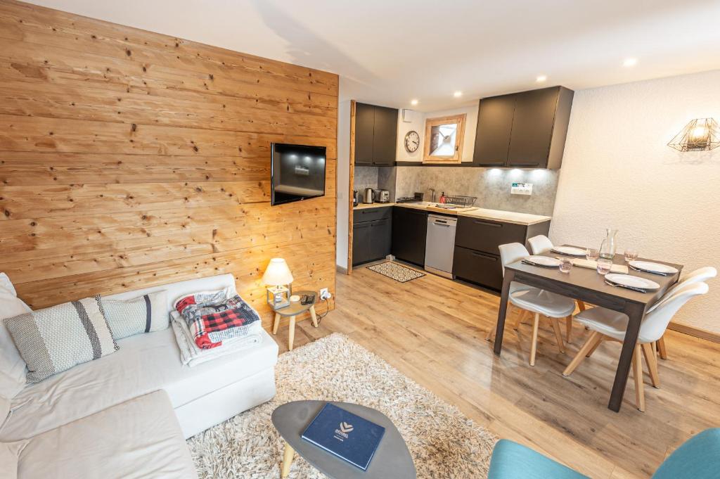 un salon avec un canapé et une table et une cuisine dans l'établissement Smartstay - Appartement au pied des pistes, à Méribel