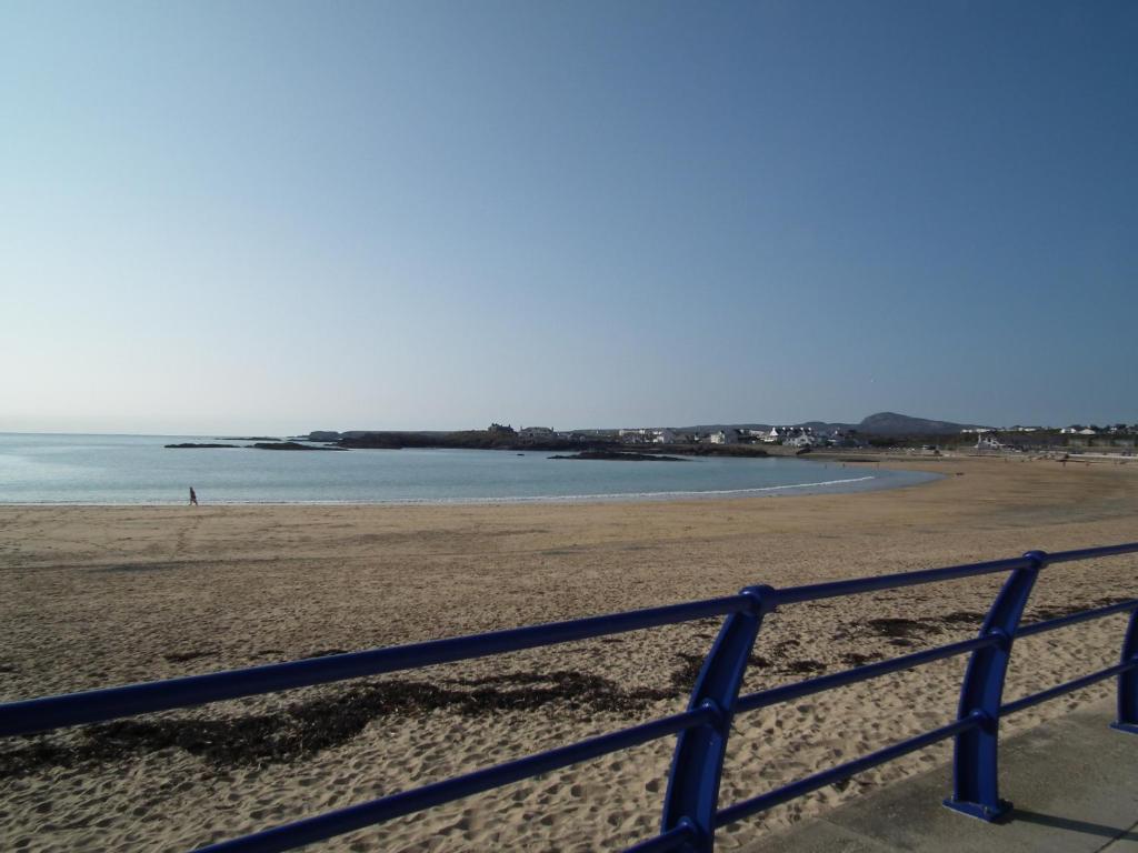 a view of a beach with a blue fence at The Beach Motel in Trearddur