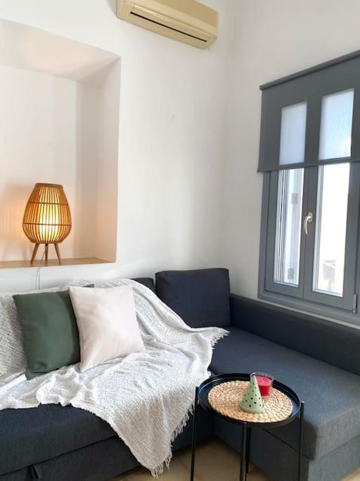 a living room with a blue couch and a table at Artemonas White Escape in Sifnos