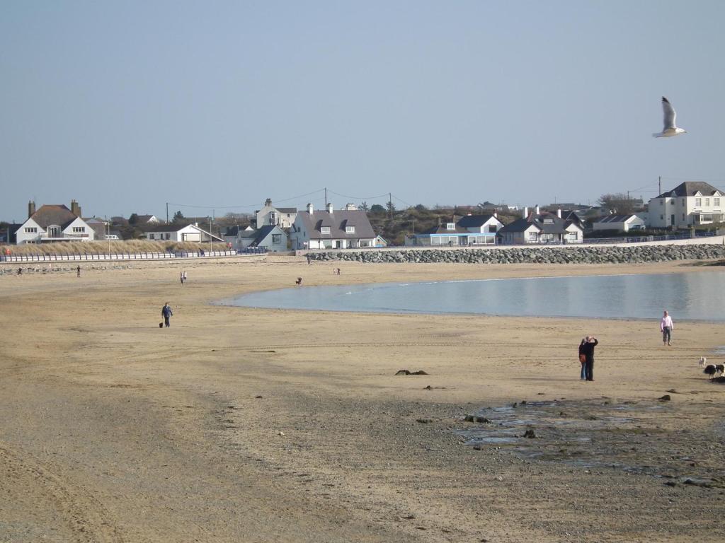 a group of people walking on the beach at The Beach Motel in Trearddur