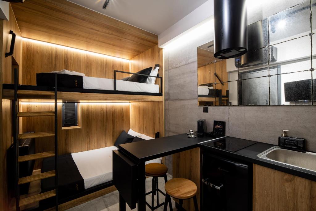 ein kleines Zimmer mit einem Etagenbett und einer Küche in der Unterkunft Industrial - Le Petit Bati in Volos