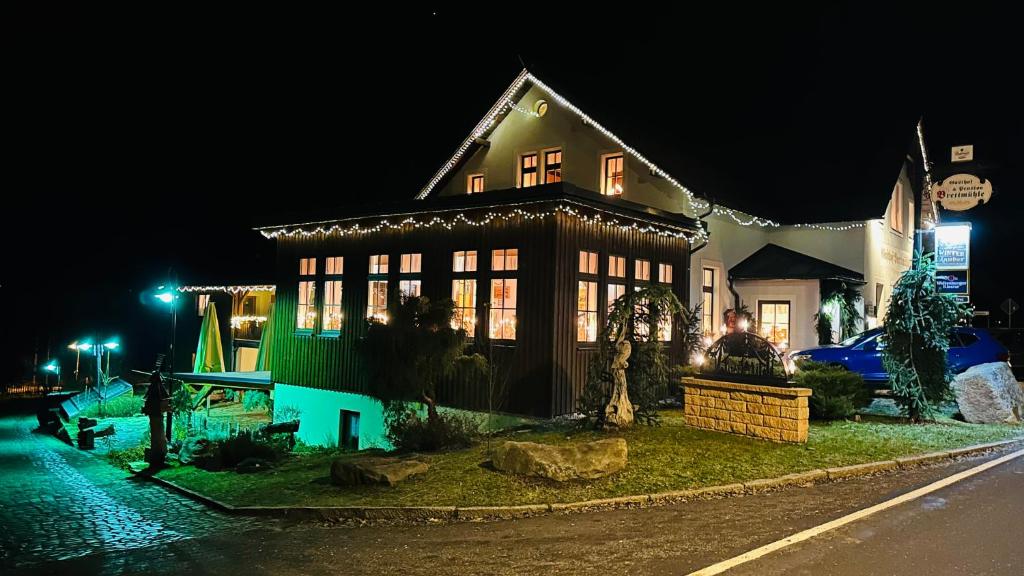 ein Haus mit Weihnachtslichtern in der Nacht in der Unterkunft Gasthof & Pension Brettmühle in Königswalde