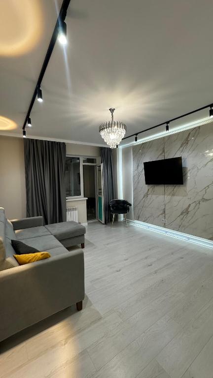 ein Wohnzimmer mit Couch und Flachbildfernseher in der Unterkunft 2-х комнатные апартаменты на Экспо in Astana