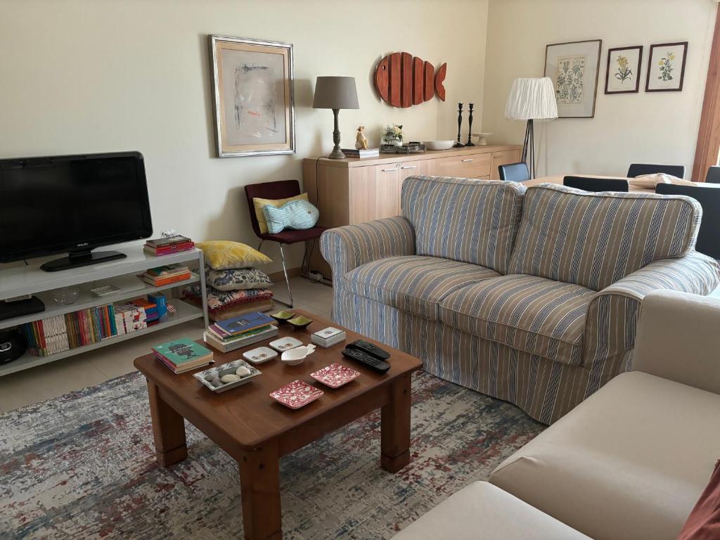 a living room with a couch and a coffee table at Lua do Mar - T2 - Piscina - Fte ao Mar- Central in Nazaré