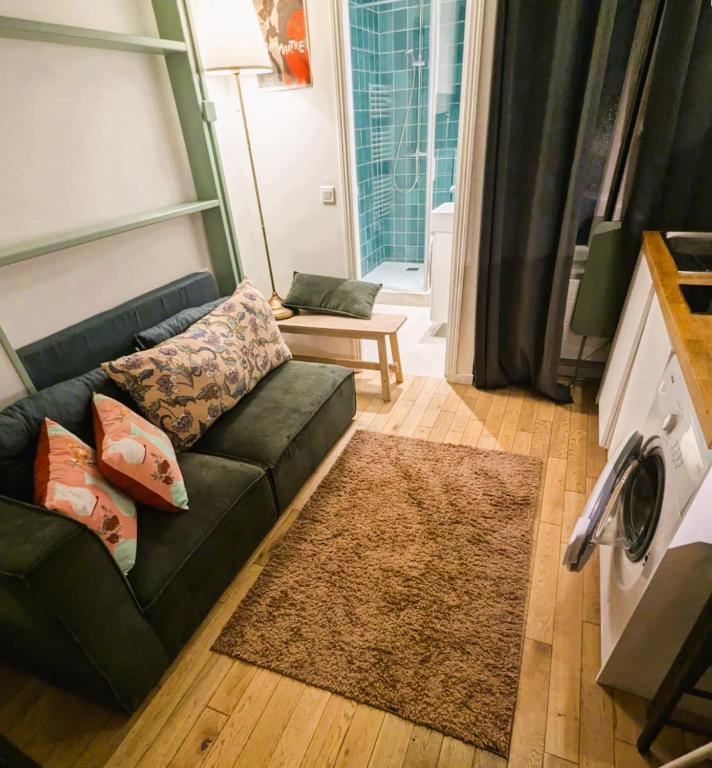 - un salon avec un canapé vert et un tapis dans l'établissement Cozy Nest - Montmartre Caulaincourt, à Paris
