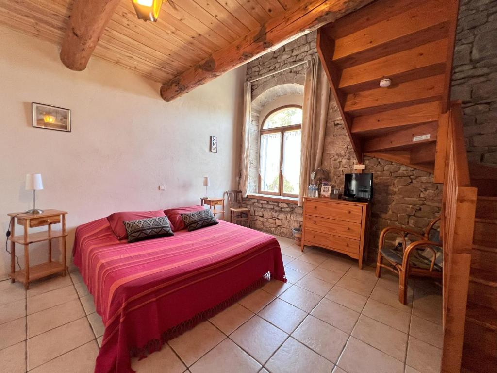 ein Schlafzimmer mit einem Bett in einem Zimmer mit einer Holzdecke in der Unterkunft Le Mas Du Gentilhomme Chambre Glycine in Orthoux-Sérignac-et-Quilhan