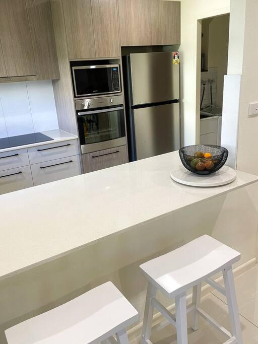 a kitchen with a bowl of fruit on a counter at CBD Esplanade Location - Quiet & Comfortable in Darwin