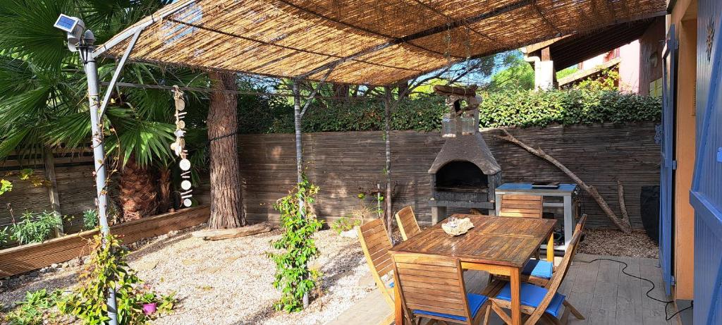 un patio avec une table et un four extérieur dans l'établissement vacances plein sud, à Narbonne-Plage