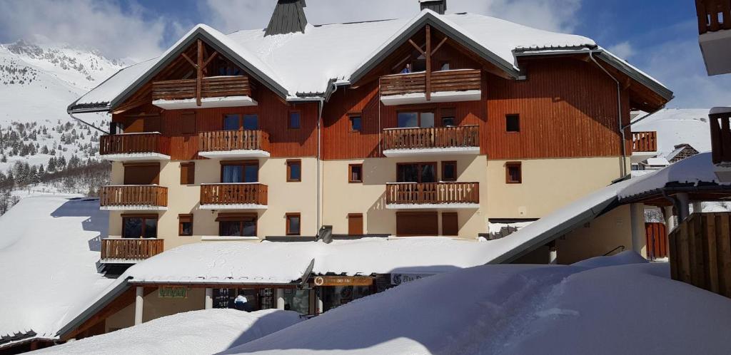 un grand bâtiment avec de la neige devant lui dans l'établissement Vos vacances à Saint François Longchamp, à Saint-François-Longchamp