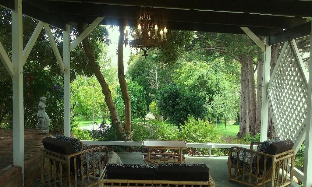 a porch with a chandelier and chairs and a table at Brookvale House Balingup in Balingup