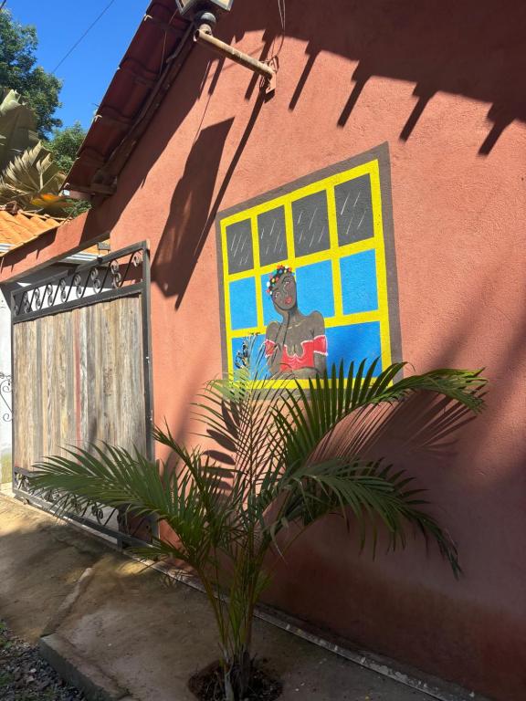 a painting on the side of a house with a plant at Casa Pouso Tiradentes 2 in Tiradentes