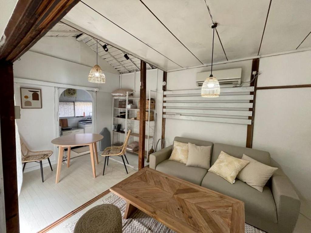 a living room with a couch and a table at 桜木町 鶴 古民家の宿 in Nishi-hiranumachō