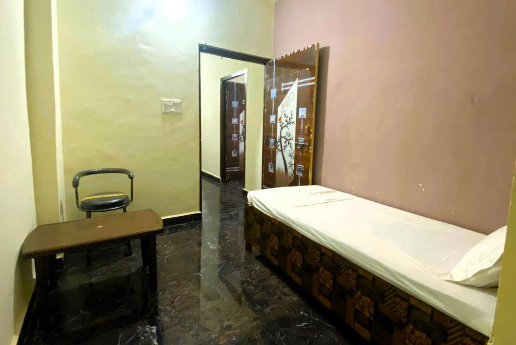 una camera con letto, sedia e specchio di BSSN Guest House a Gwalior