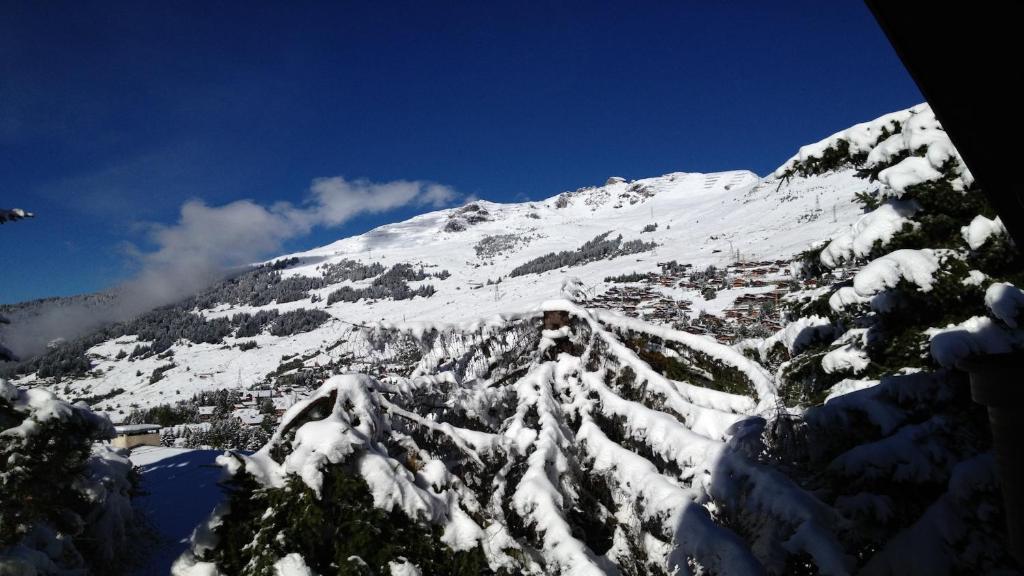 a mountain covered in snow with a town at Chalet Taipan Verbier in Verbier