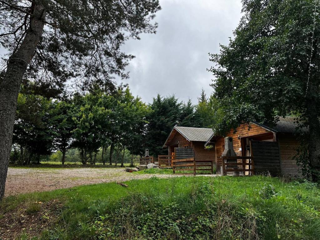 a log cabin in the middle of a field at Camping & Chalets La Santoire in Saint-Bonnet-de-Condat