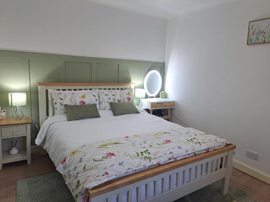 a bedroom with a large bed and a mirror at Cliff Cottage in Valtos