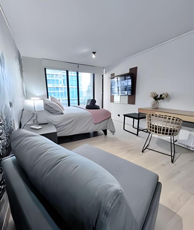 a bedroom with a bed and a couch at Estudio chic al costado CLC in Santiago