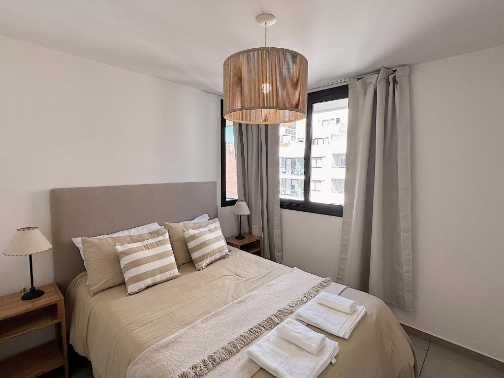 ein Schlafzimmer mit einem Bett mit zwei Handtüchern darauf in der Unterkunft Apartamento Obispo Trejo, Nueva Cordoba in Cordoba