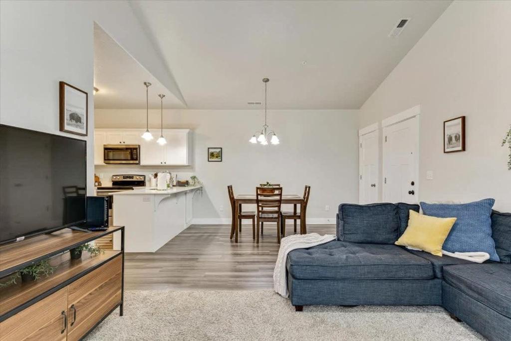 a living room with a blue couch and a kitchen at FrontRunner Lehi Station Fully Equipped Kitchen in Lehi