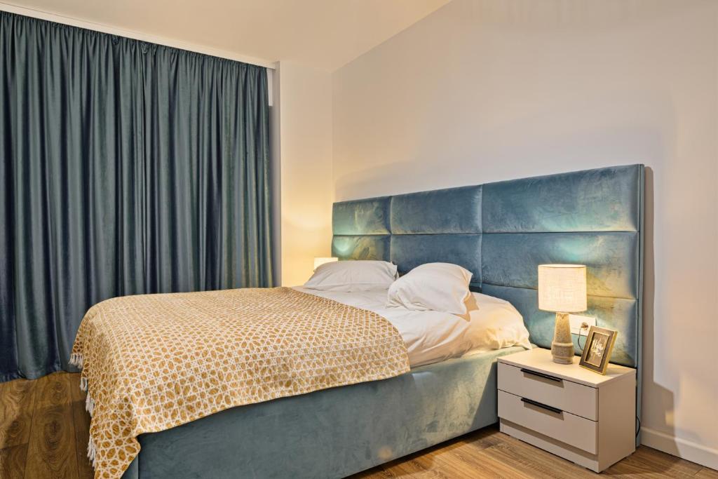 a bedroom with a large bed with a blue headboard at Mountain Bliss in Sinaia