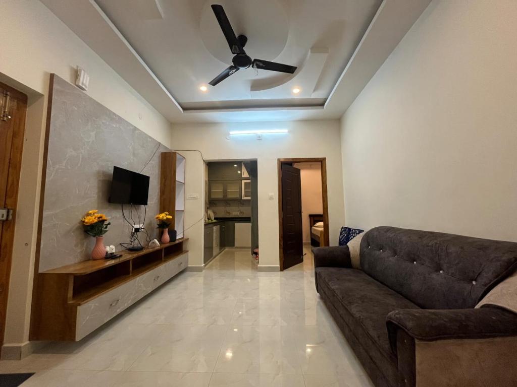 a living room with a couch and a ceiling fan at Padmavathi Homestay -2BHK 1BHK AC Apartments for group of families - Best location - Flyover to Alipiri gate - Walk to PS4 Veg Restaurant - Modular Kitchen - Super fast Wi-Fi- Near to Tirupati Bus Stand 2 KM-Near to Railway Station 2KM in Tirupati