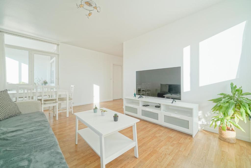 a white living room with a couch and a table at Appartement familial - proche Paris in Alfortville