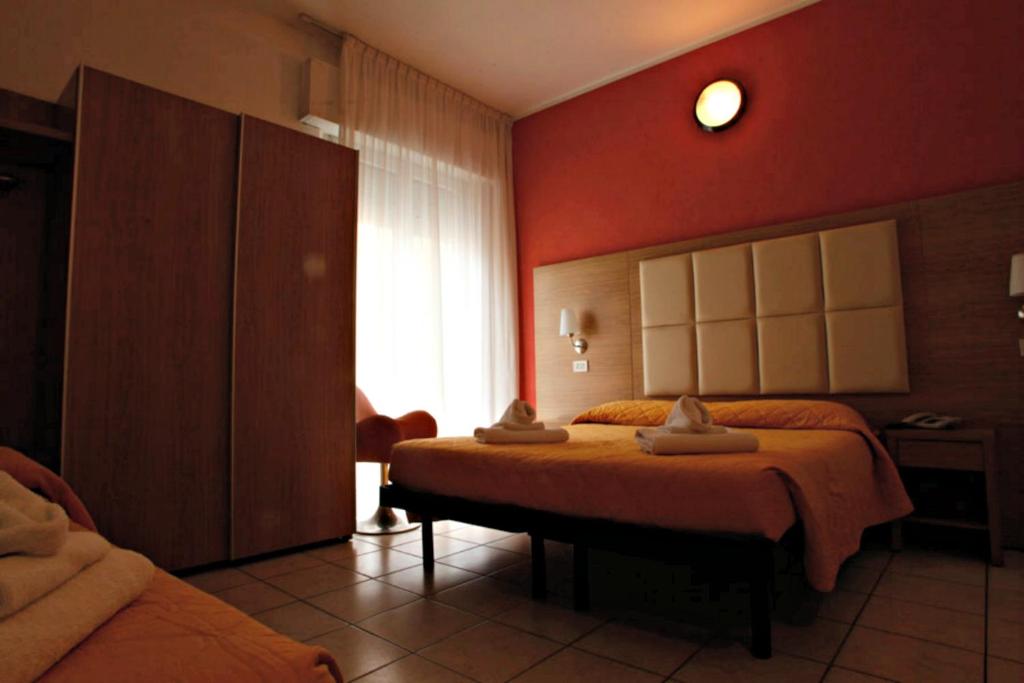 リミニにあるHotel Marebelloのベッドと窓が備わるホテルルーム