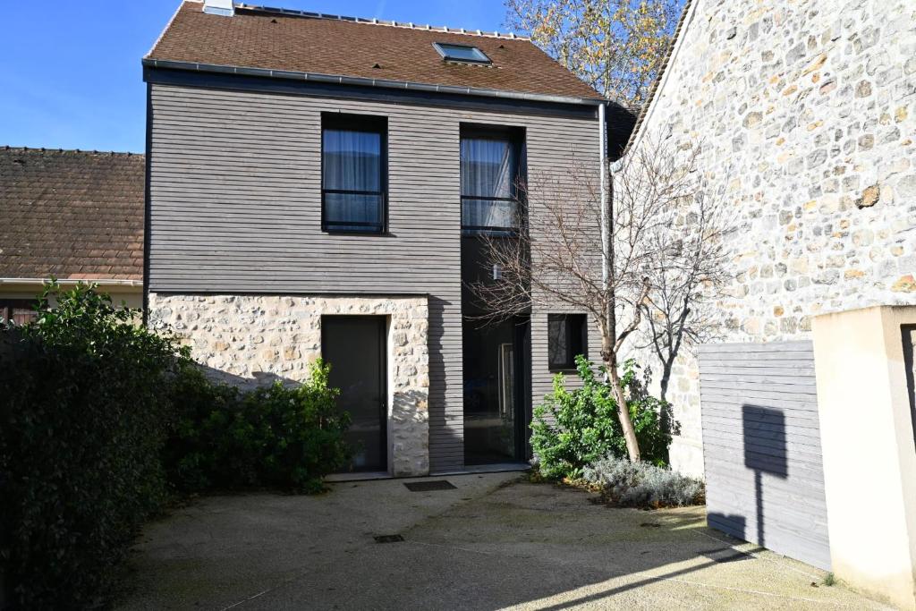 une ancienne maison avec un bâtiment en pierre et un aphalt dans l'établissement Natural Design Lodge Jacuzzi Privatif, à Milly-la-Forêt
