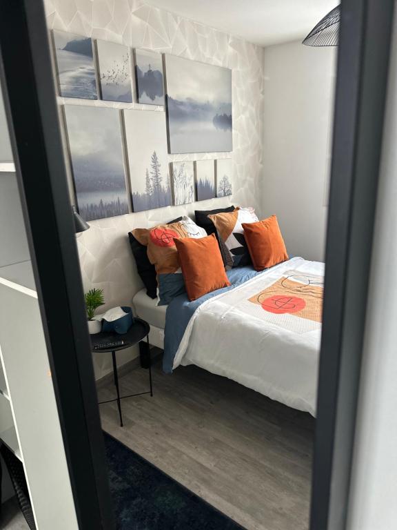 1 dormitorio con 1 cama con almohadas de color naranja y azul en Cosy & Style blue forest room proche CDG AirPort, en Tremblay-en-France