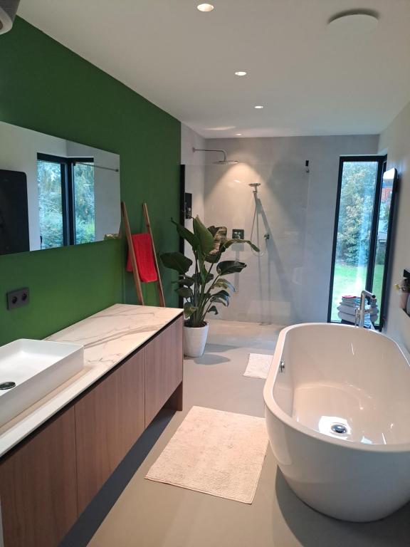 a bathroom with a large tub and a sink at Modern spatious house near Bruges in Bruges
