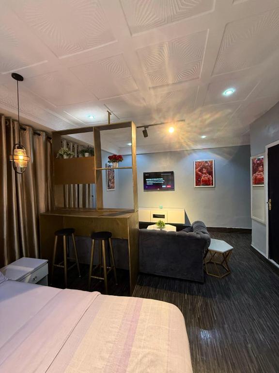 a room with a bed and a couch and a bar at Big Studio Unit in Lekki phase 1 - Kitchen, Washer, 24-7 light, WiFi & Netflix in Lagos