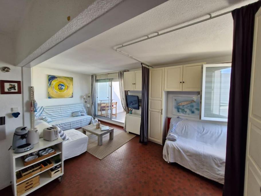 une chambre avec deux lits et un salon dans l'établissement Appartement le Barcares vue mer, au Barcarès