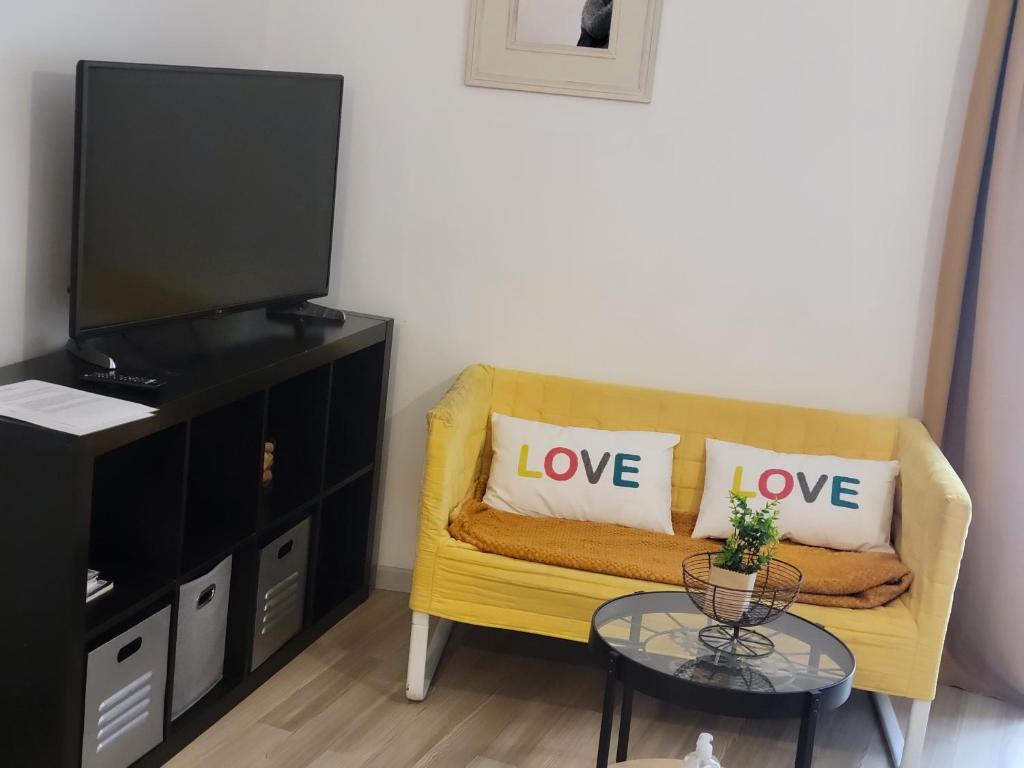 - un salon avec un canapé jaune et des oreillers dans l'établissement Studio au coeur de Viviers, à Viviers