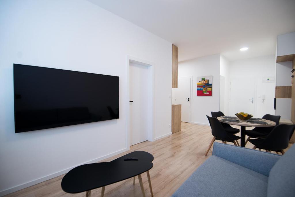 a living room with a flat screen tv on a wall at Apartmán Dominanta in Liptovský Mikuláš