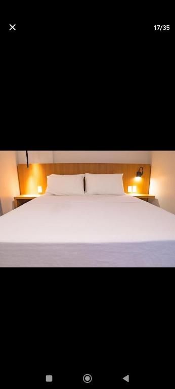 a bedroom with a white bed with two white pillows at Salinas Premium Resort in Salinópolis
