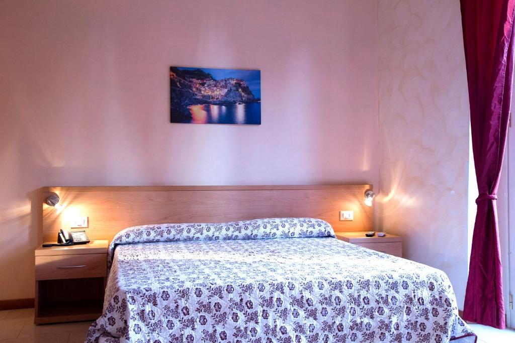 a bedroom with a bed and two night stands at Hotel Villa Flora in Bogliasco
