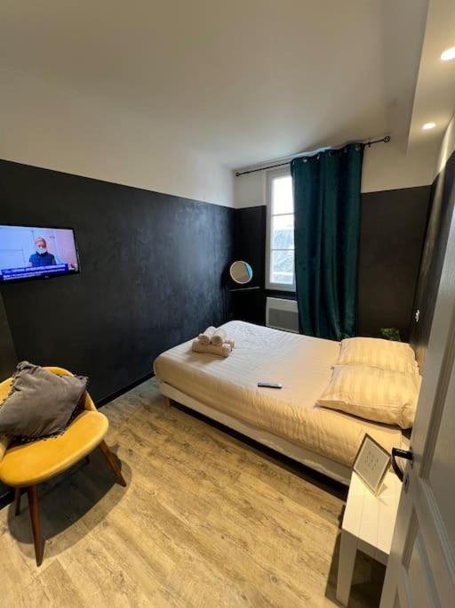 - une chambre avec un lit, une chaise et une télévision dans l'établissement Échec et Mat chic - Gare & Hyper Centre, à Angers