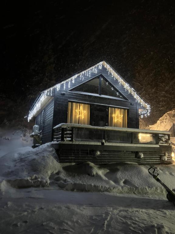 a small house in the snow at night at Evenes Artic glamping in Evenesmarkja