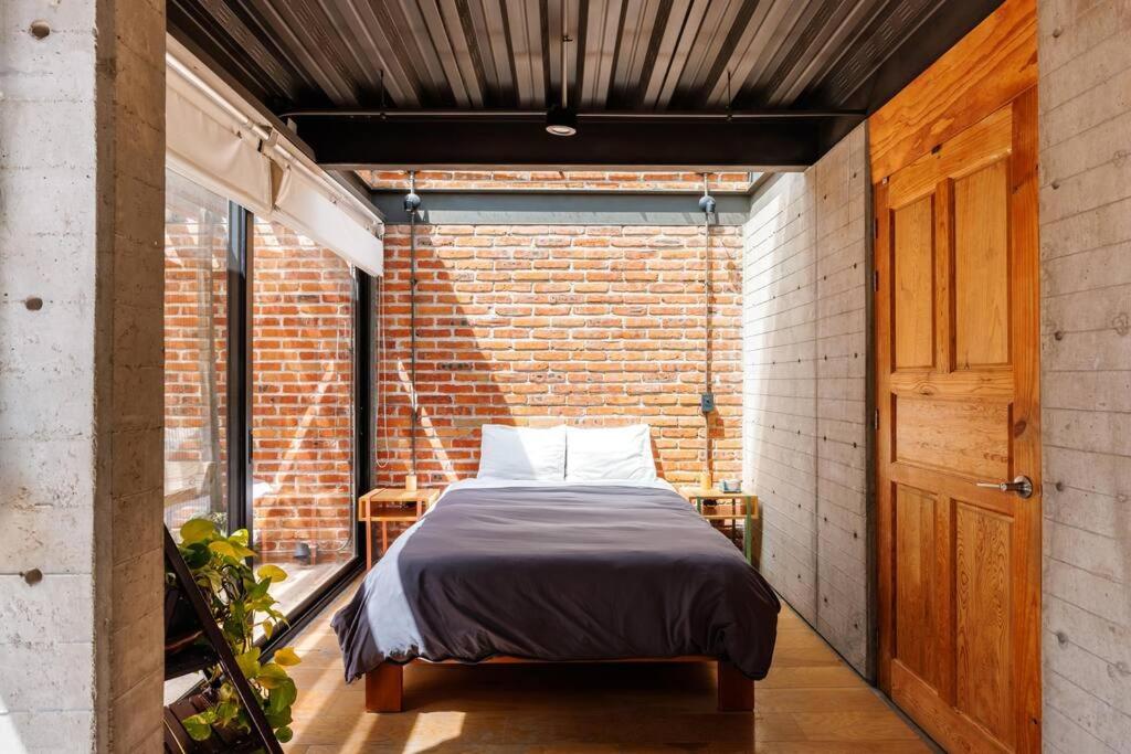 a bedroom with a bed in a brick wall at Casa Franco - Modern Architecture Home with AC in San Miguel de Allende
