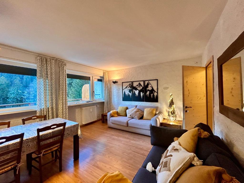 a living room with a couch and a table at Central recently renovated apartment - Casa Tre Pini in Madonna di Campiglio