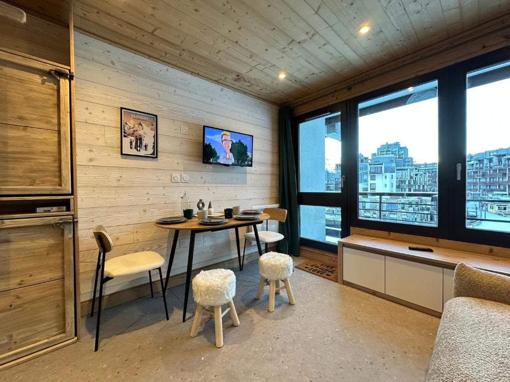 une salle à manger avec une table, des chaises et des fenêtres dans l'établissement Studio les Tufs pied des pistes Tignes Val Claret départ ESF, à Tignes
