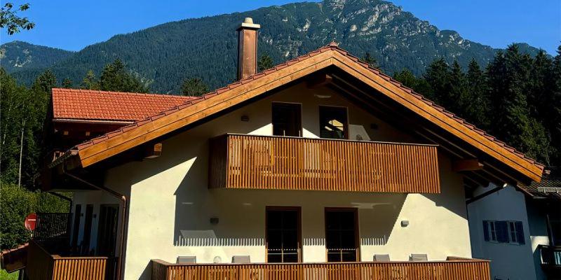 a house with a balcony with a mountain in the background at Alpenchalets Zugspitze in Grainau
