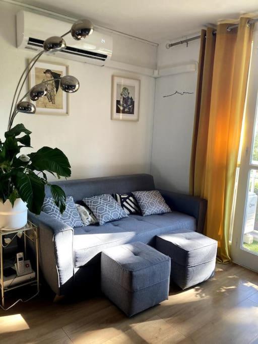 un salon avec un canapé bleu dans une pièce dans l'établissement Flat air conditioning 4 people near stadium beach, à Marseille