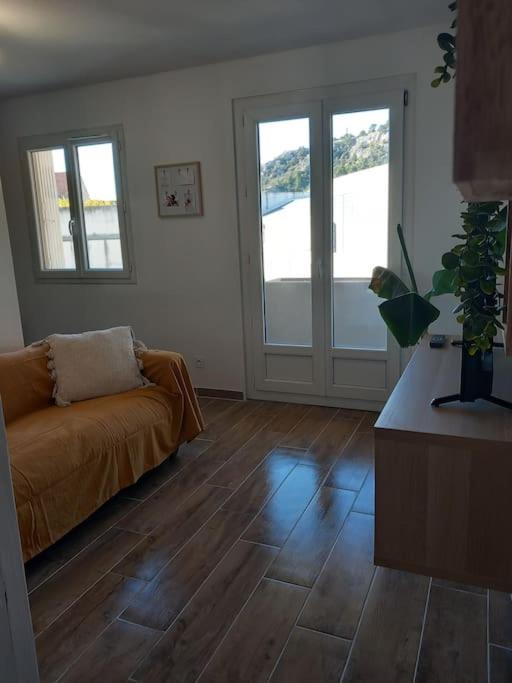 - un salon avec un canapé et du parquet dans l'établissement Studio entièrement rénové, à Cavaillon