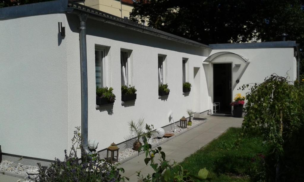 a white house with potted plants on the side of it at BerLietz in Berlin