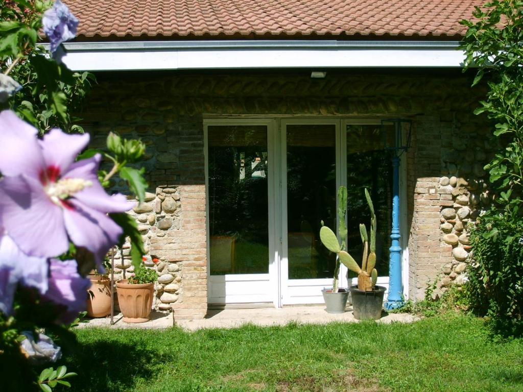 a front door of a house with potted plants at La Ferme de Thoudiere in Saint-Étienne-de-Saint-Geoirs