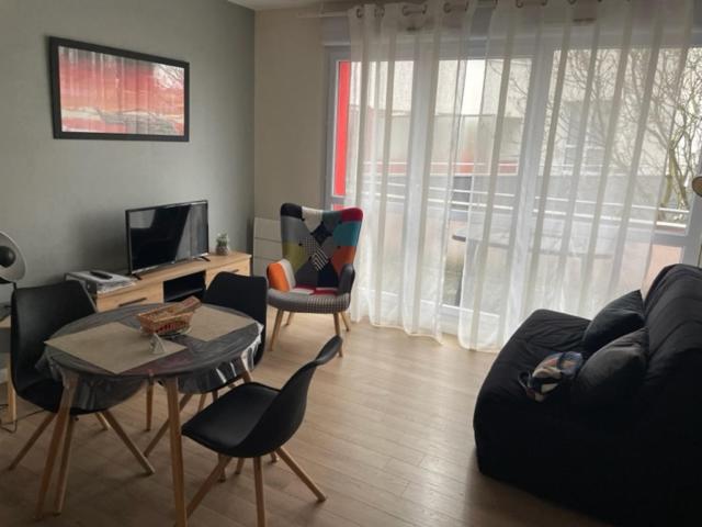 un salon avec un canapé, des chaises et une table dans l'établissement Patbad85, à La Roche-sur-Yon