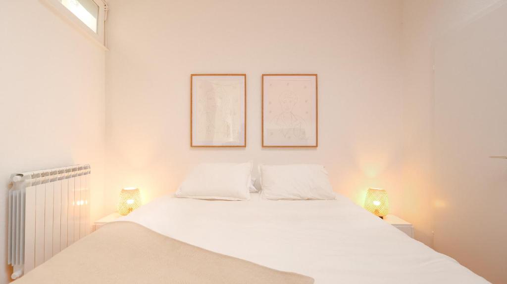 a bedroom with a white bed with two lamps at grand loft avec patio proche des quais Strasbourg in Strasbourg
