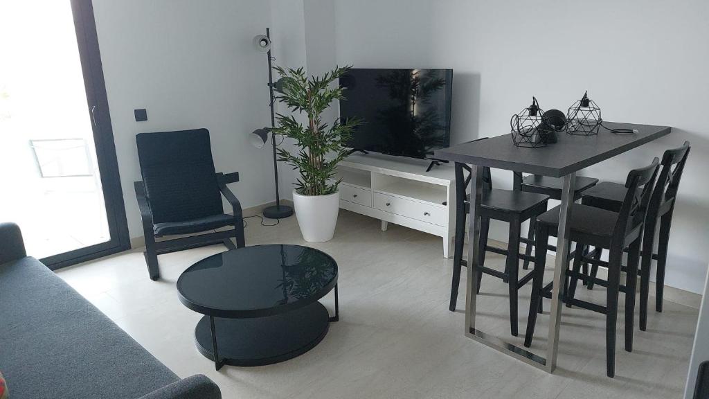 a living room with a table and chairs and a television at LHOME CÁDIZ in Cádiz