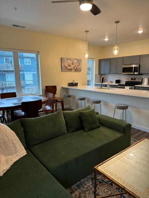 a living room with a green couch and a kitchen at N Walnut Street in Bloomington